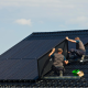 Technicians installing Victron inverters on residential solar panel system for off-grid power